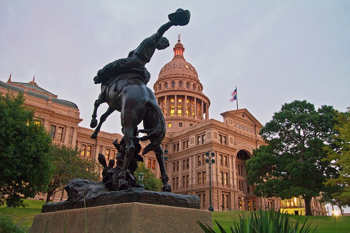 Austin, Texas. Cowboy Memorial in front of Texas Capitol dome.
